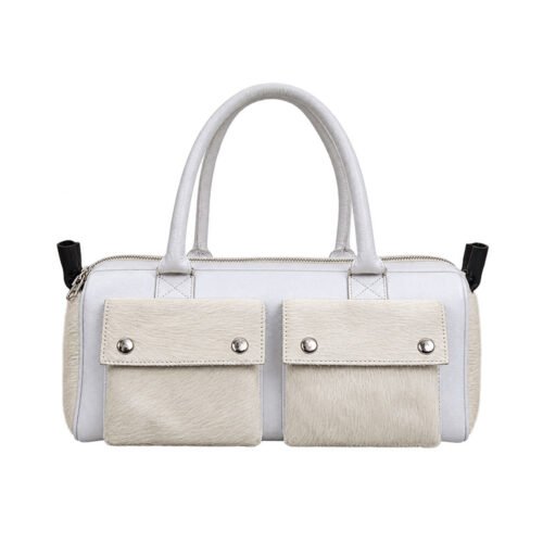 White tote handbag with cream hair-on-hide front pockets, double handles, silver-tone snap closures, and a top zipper.