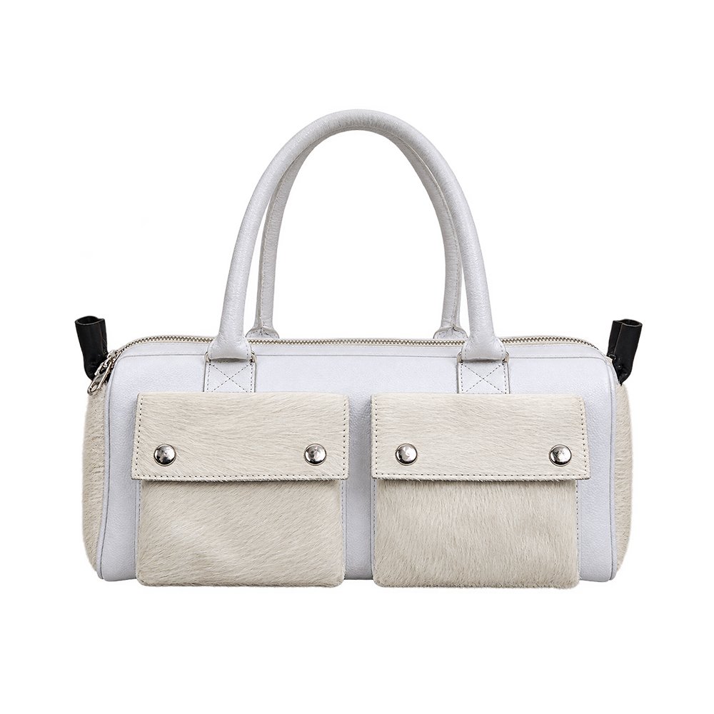 White tote handbag with cream hair-on-hide front pockets, double handles, silver-tone snap closures, and a top zipper.